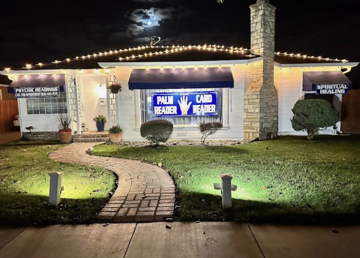 Elaina's psychic reading house at night, glowing with its neon Psychic Reader sign — a Central Coast landmark